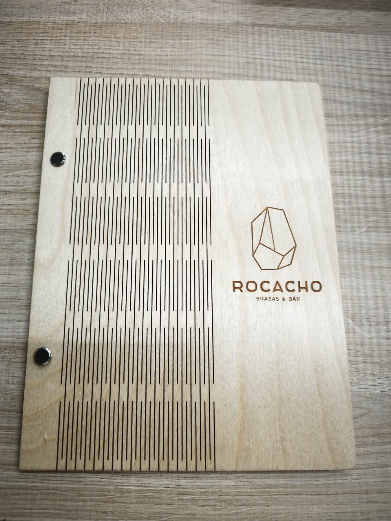 Cubierta de madera para la carta del restaurante Rocacho con logotipo grabado